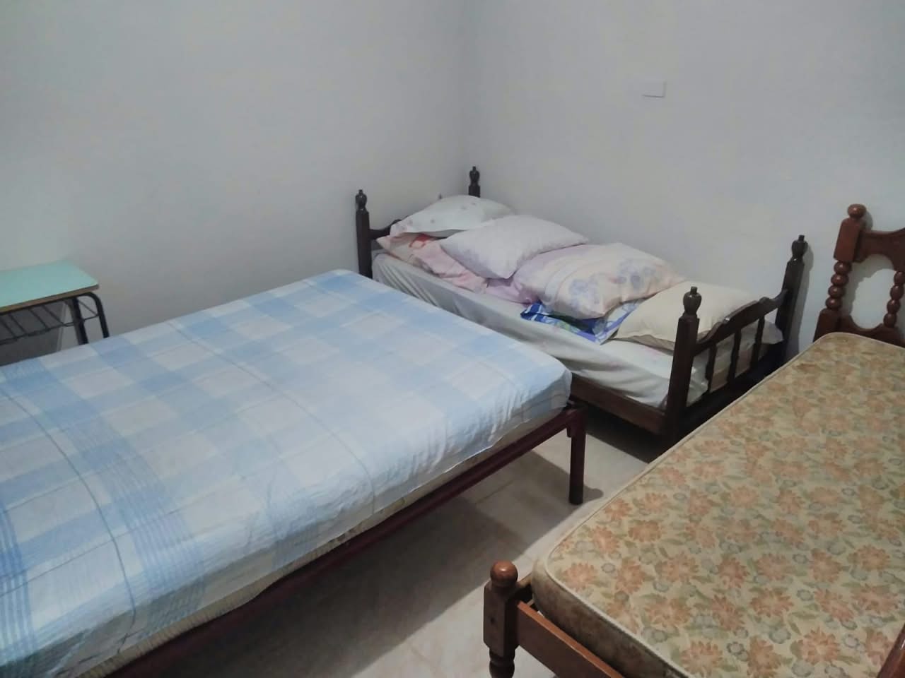 Quarto de hospedagem da chácara com várias camas, demonstrando a capacidade de pernoite para grupos.